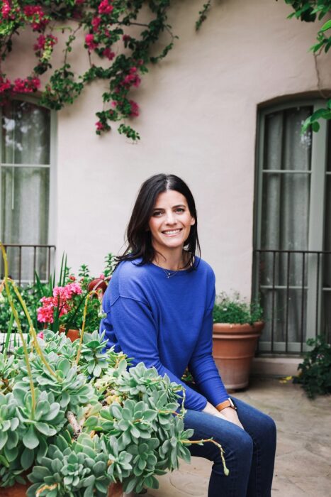 hilton & hyland real estate agent lisa optican sits in a garden