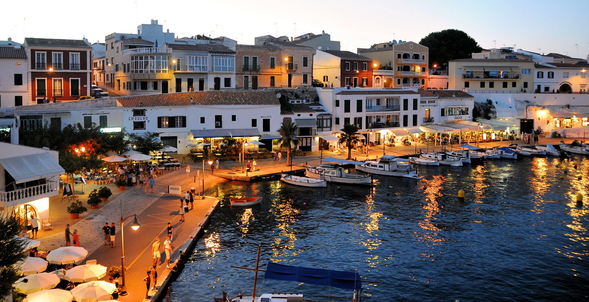 waterfront city in spain at night with boats and homes