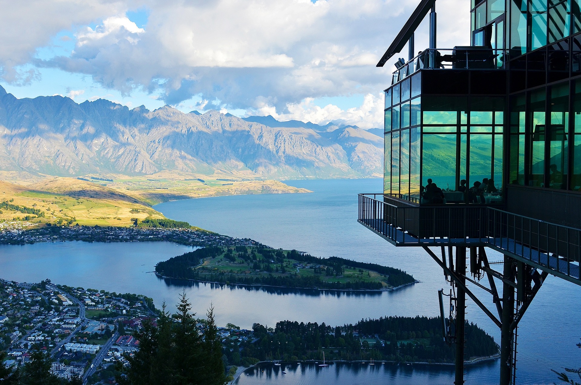 modern architectural glass house overlooking a lake in new zealand