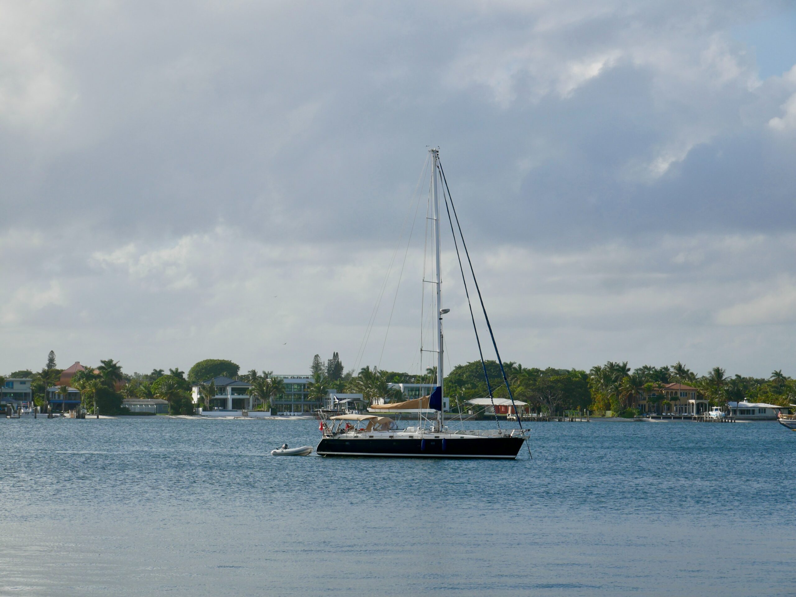 palm beach waterway with passing boat and luxury homes in background